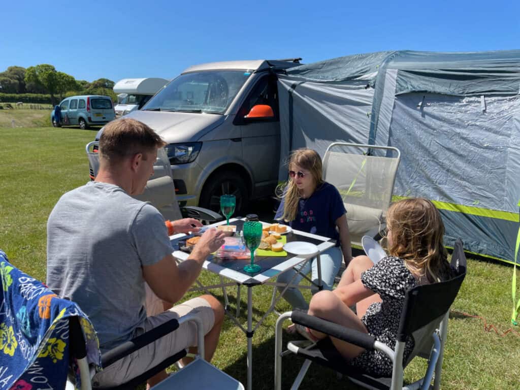 Family eating lunch in front of camper van