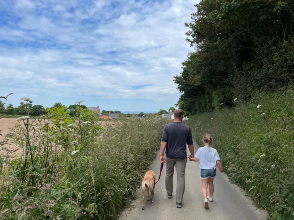 Family walking along narrow road in Jersey