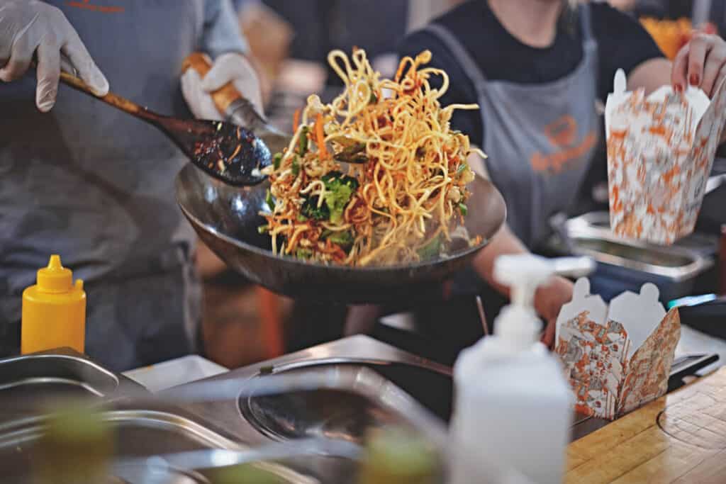 Cooking noodles in wok at street food stall
