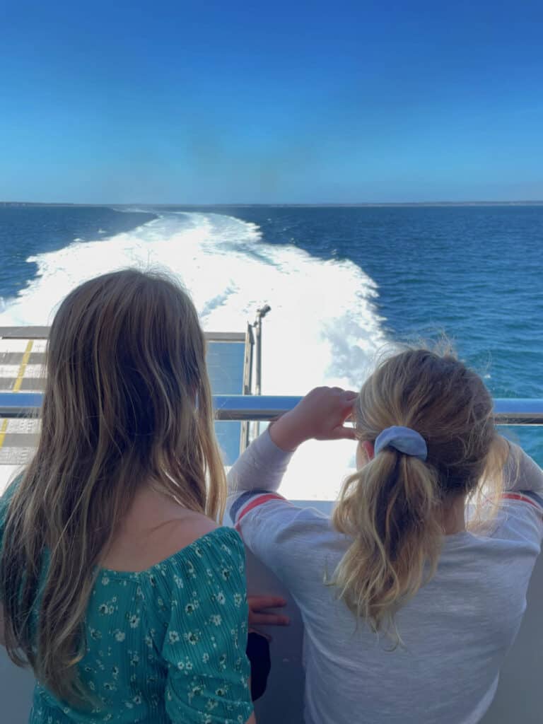 Girls looking out the back of a ferry at the wash