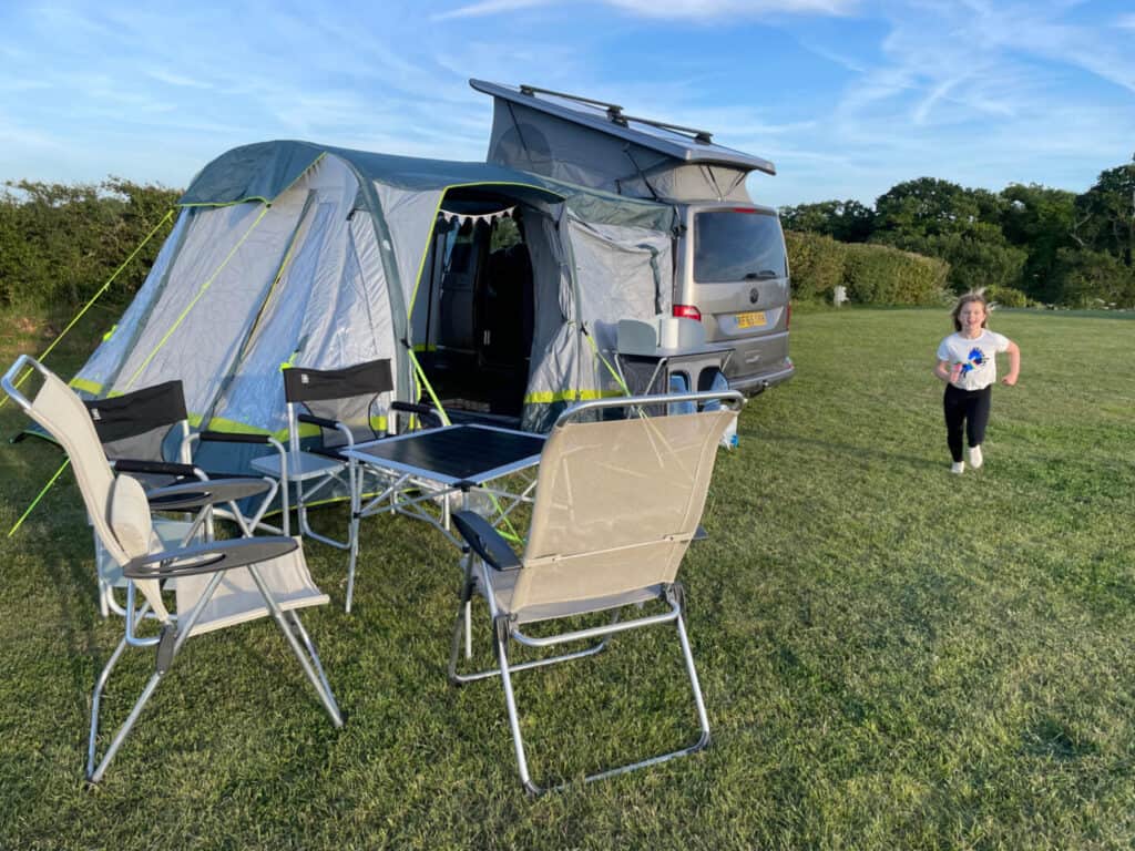 Child running past camper van on campsite