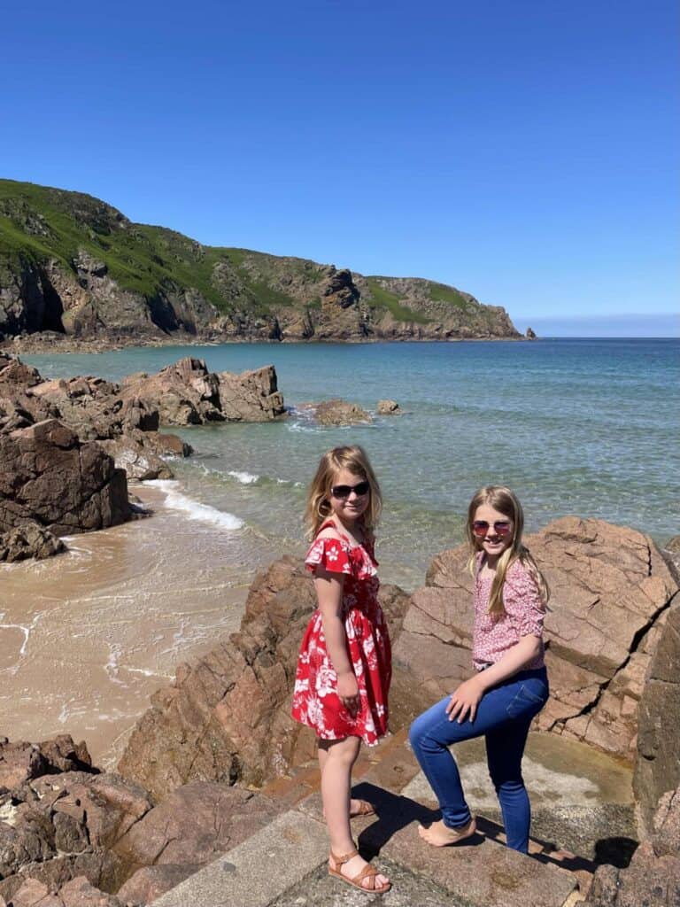 Girls stood on steps in front of Plemont Beach in Jersey