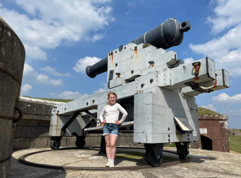 Child stood with large gun on ramparts of Fort Nelson