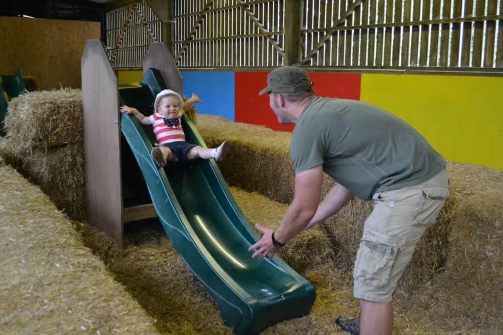 Child on slide in straw barn Longdown