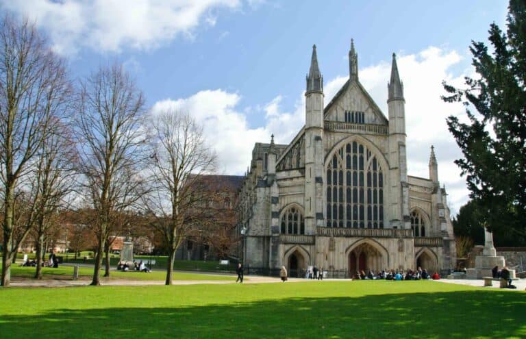 People enjoying the sun on Winchester Cathedral Green