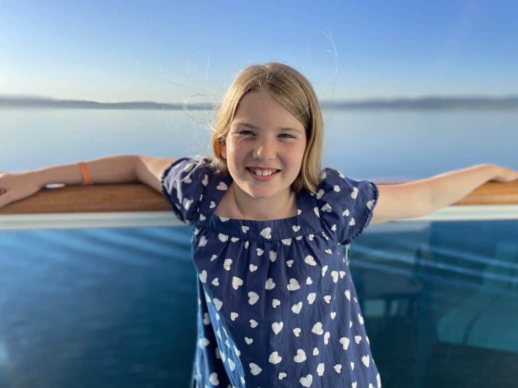 Child stood on cruise ship balcony with seascape behind