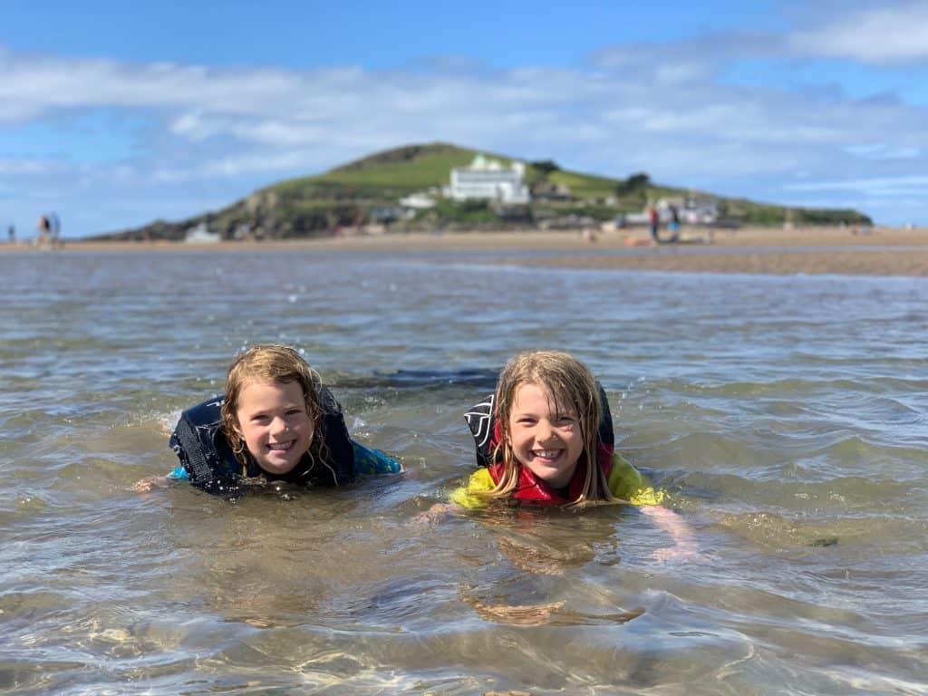 Kids in the sea at Bigbury with Burgh Island in the background