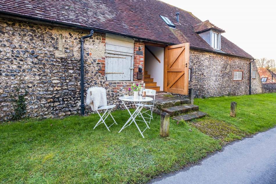 White two seater table and chairs outside converted barn