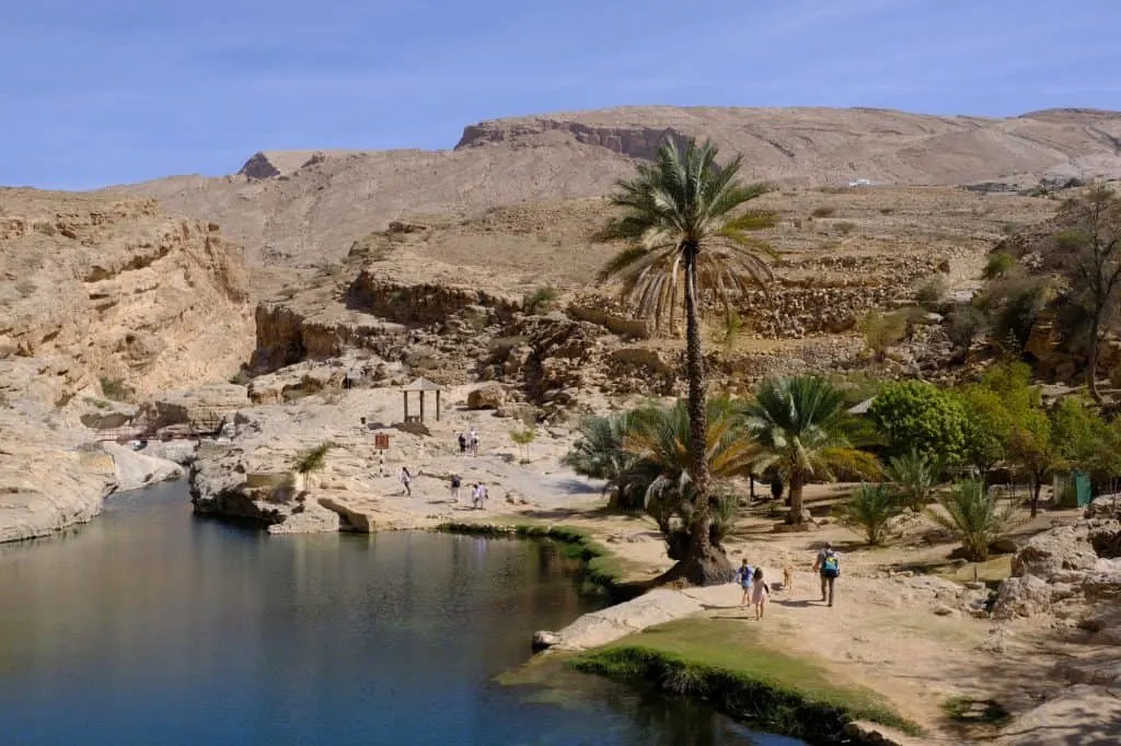 A view into the valley showing the first pool and the way towards the wadi walk. The family walks in the foreground on the right