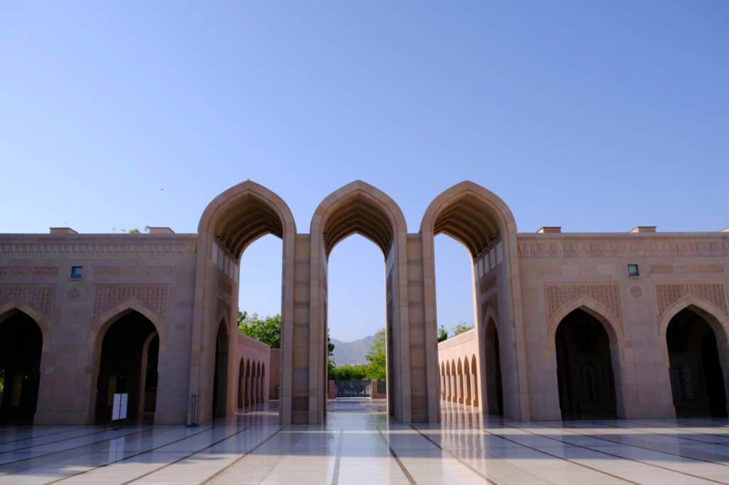 Three high sandstone arches with a view of mountains beyond