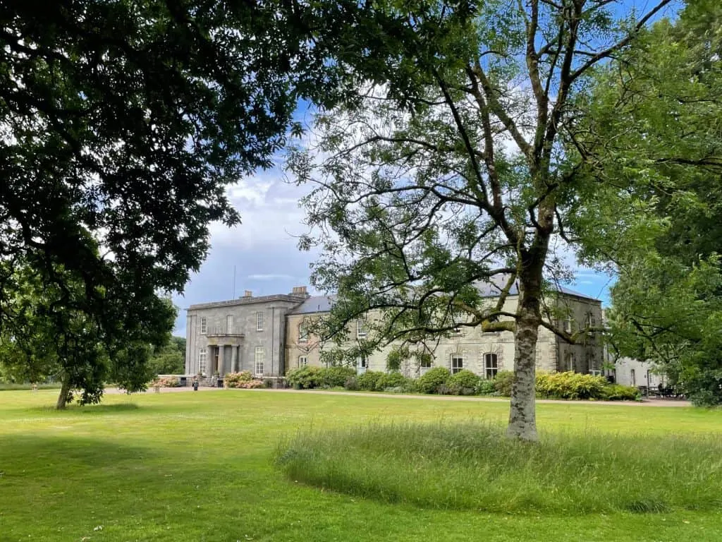 View across parkland to cream colour stately home on a spring day