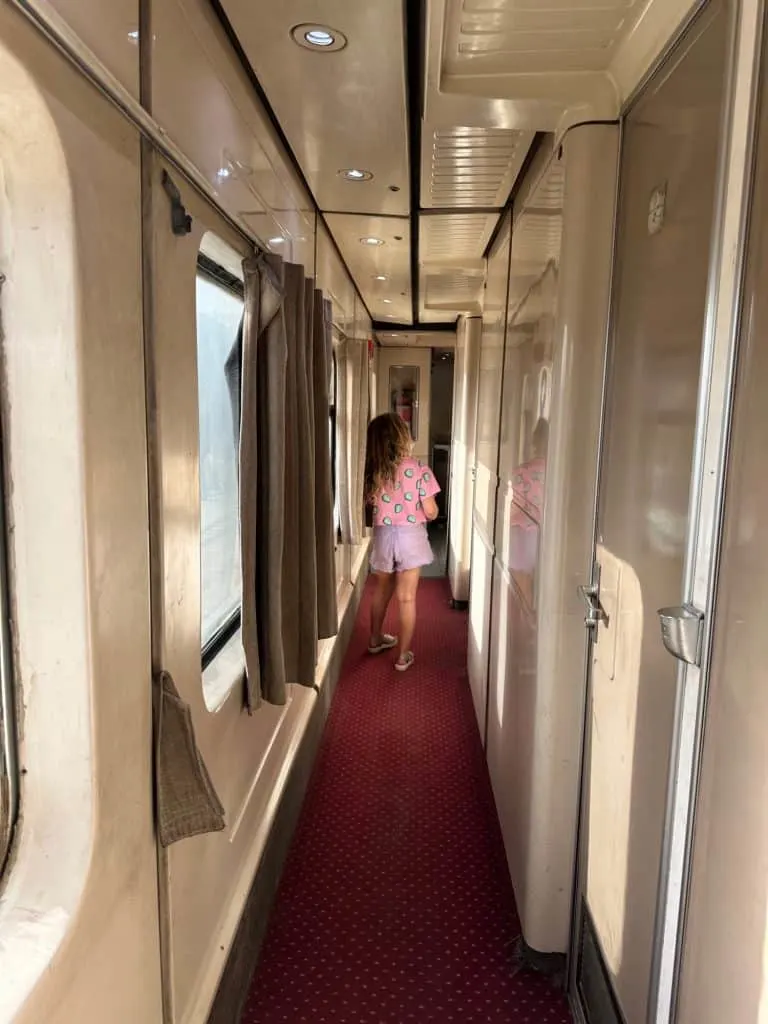 Girl walking along the corridor of the sleeper train from Cairo to Aswan in daylight