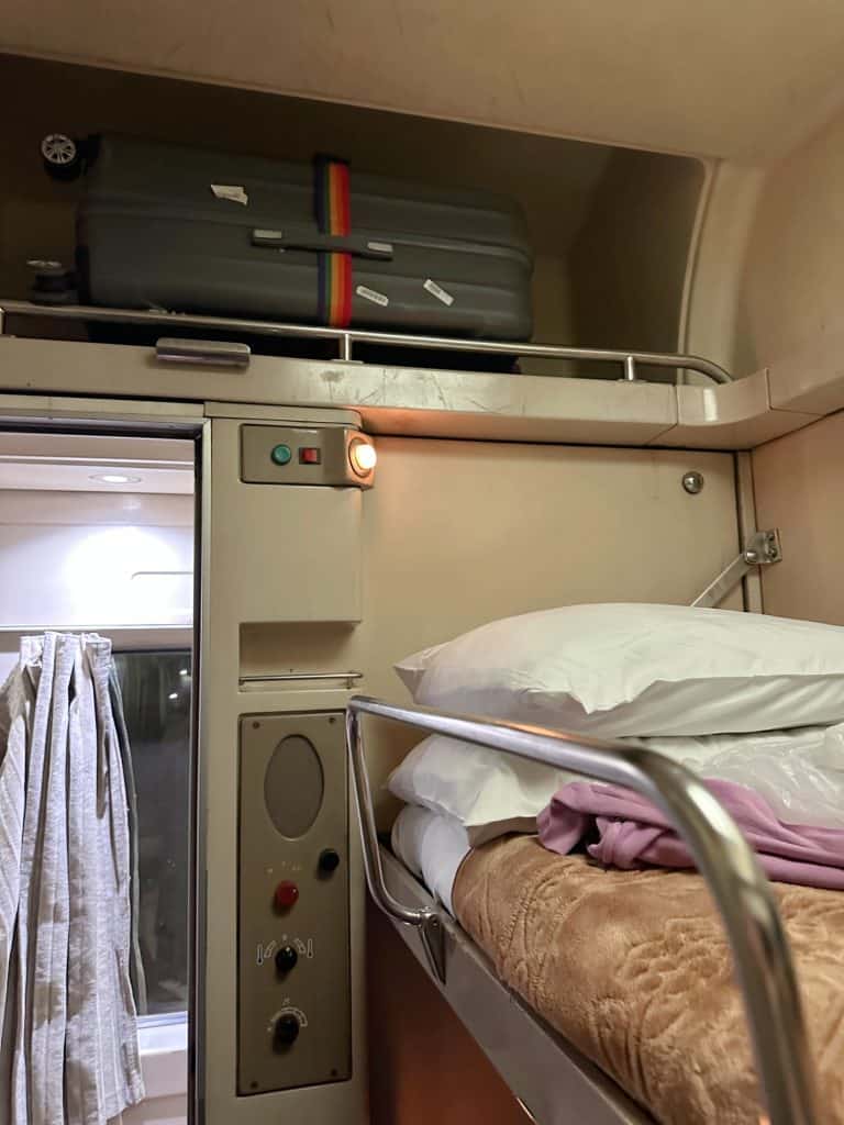 Suitcase in a cubby hole above the top bunk on the train