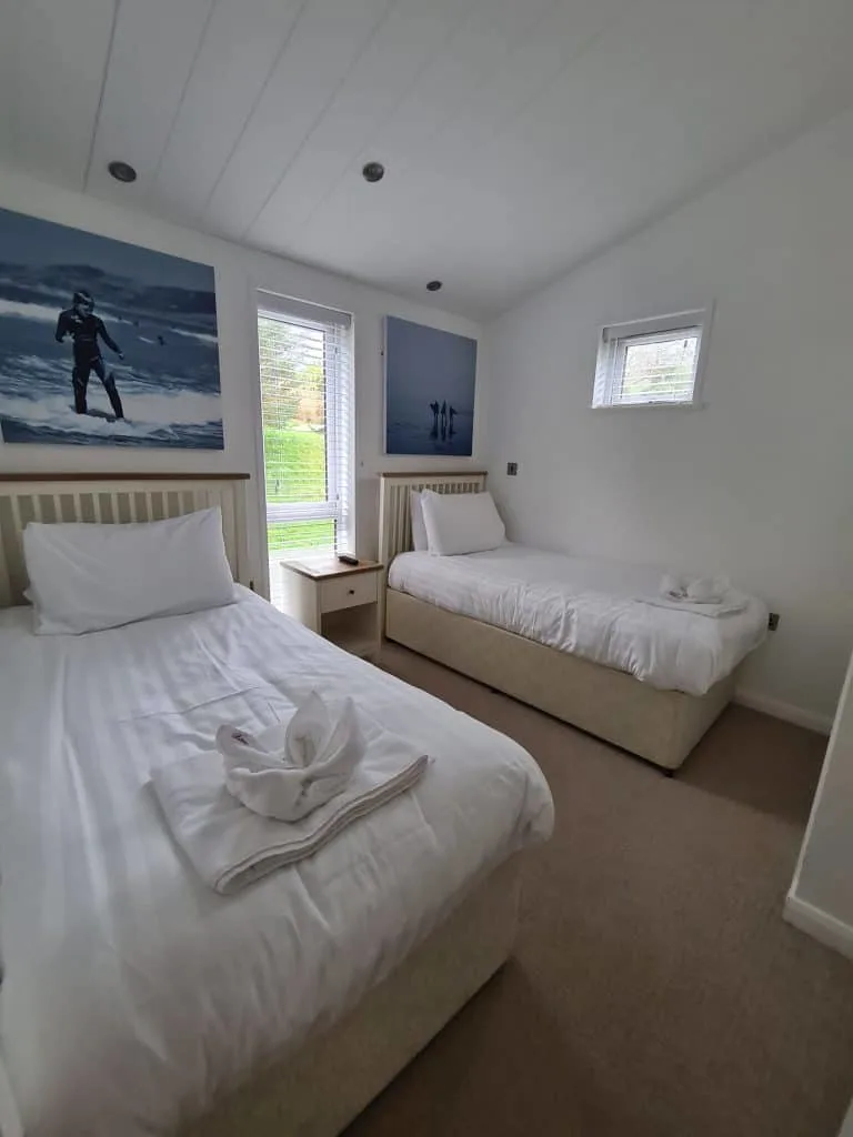 Single beds in twin bedroom. There are ocean scenes about the headboards