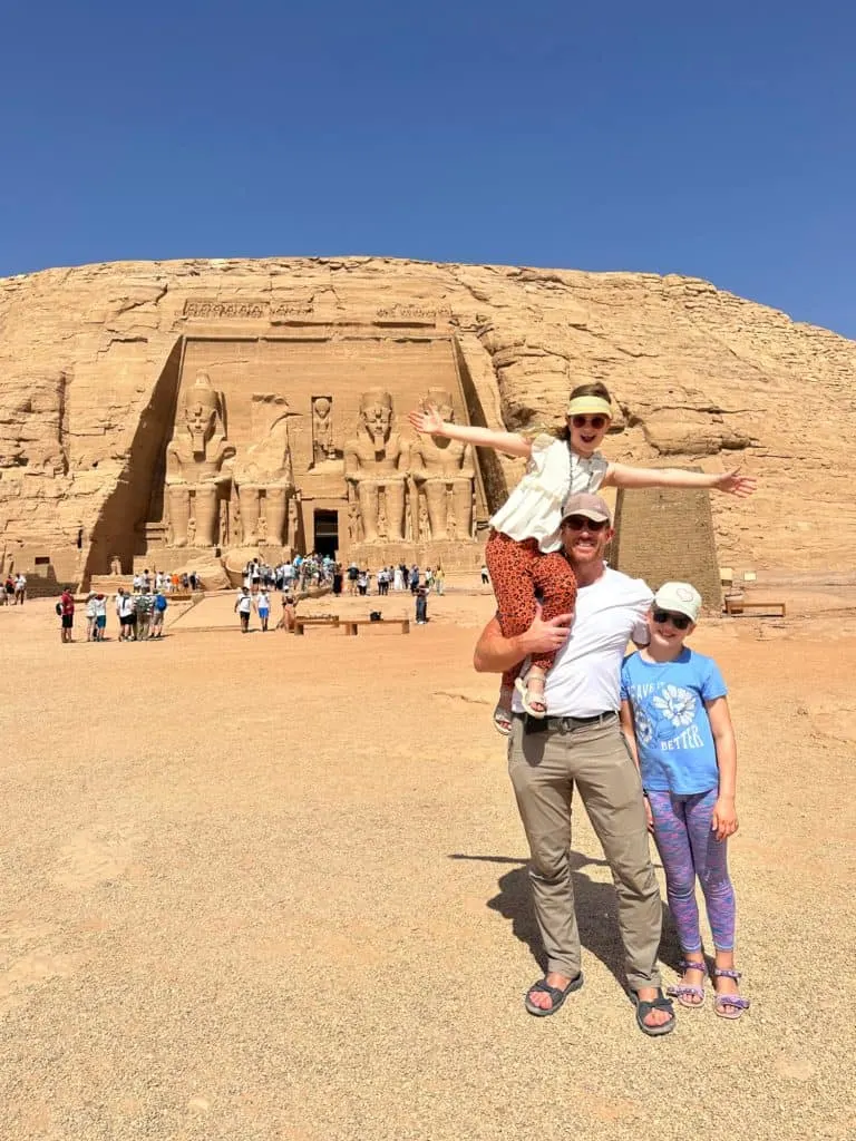 Mr Tin Box and daughters in from to Rameses II's temple at Abu Simbel. One daughter is on his shoulder and the other is standing by his side