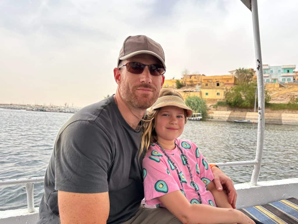 Mr Tin Box and daughter sat on ferry boat with view of the Nile behind them