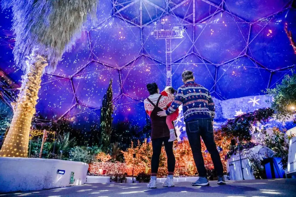 Family gazes up at colourful illuminations in the biome at Eden Project