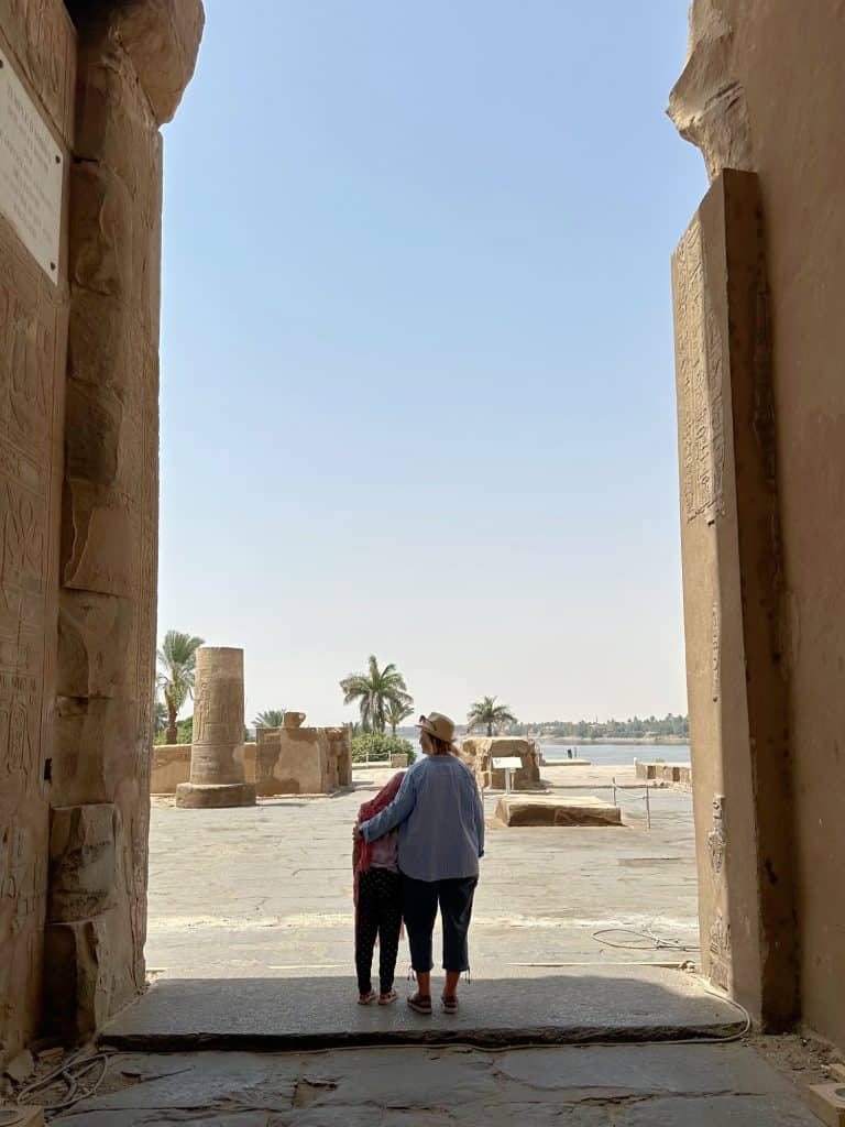 Mother and daughter stood at the entrance of Kom Ombo Temple looking out towards the Nile