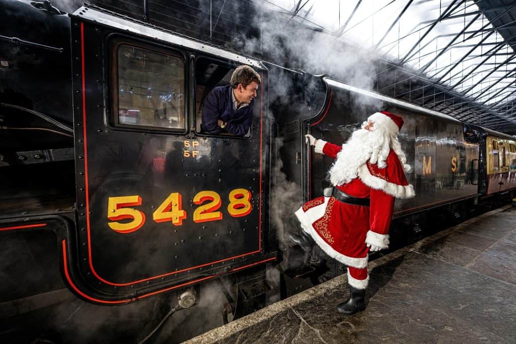 Santa is stepping into the driver's cab of a vintage train at North Yorkshire Model Railway