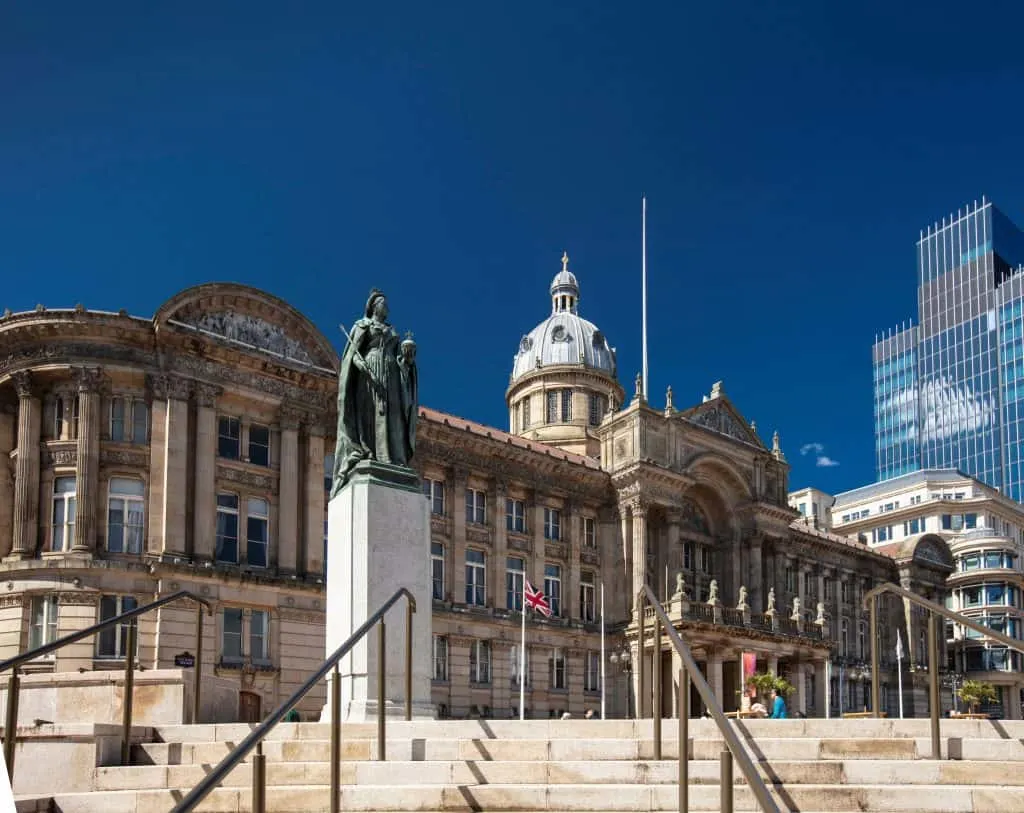 Exterior of Birmingham Museum & Art Gallery and statue of Queen Victoria against a blue sky
