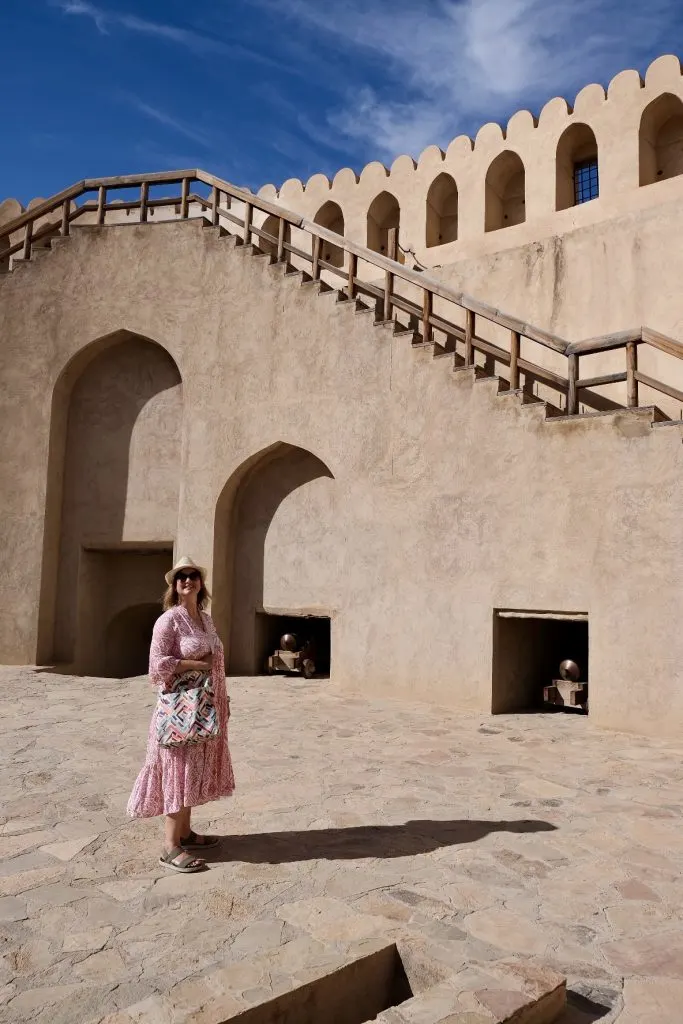 Claire wearing long dress, hat and sun glasses at Nizwa Fort