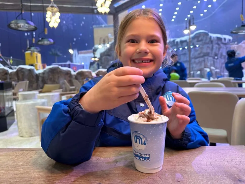 Girl smiling while stirring a hot chocolate