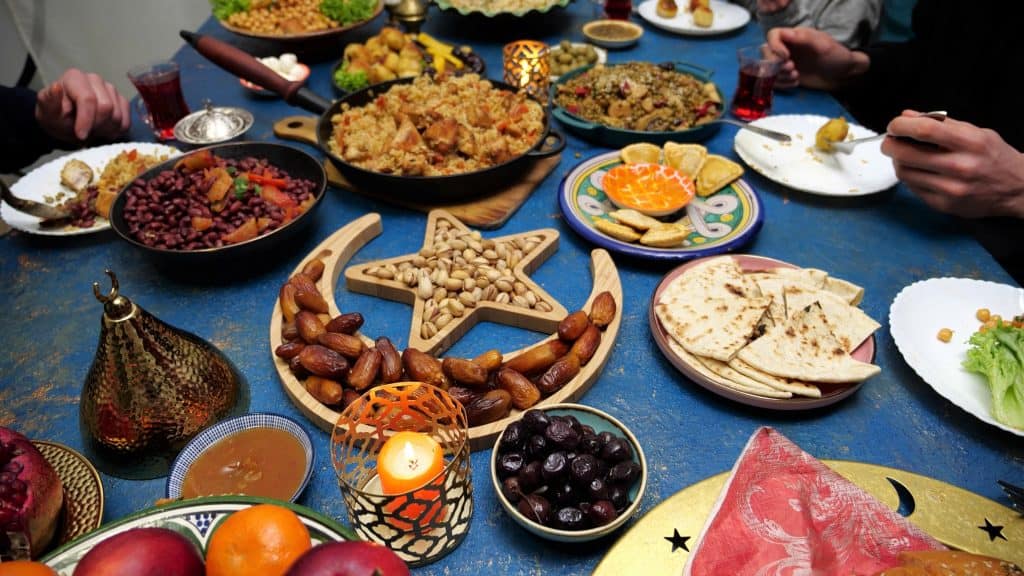Ramadan iftar Eid. Muslim family has dinner at home. Table with traditional food. Eid al-Fitr celebrations.