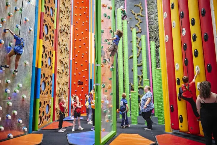 Families climb multi-coloured climbing walls