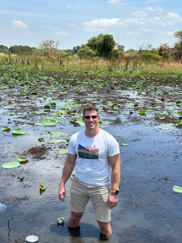 Mr Tin Box standing up to his knees in Hiriwidunna lake with lily pads all around