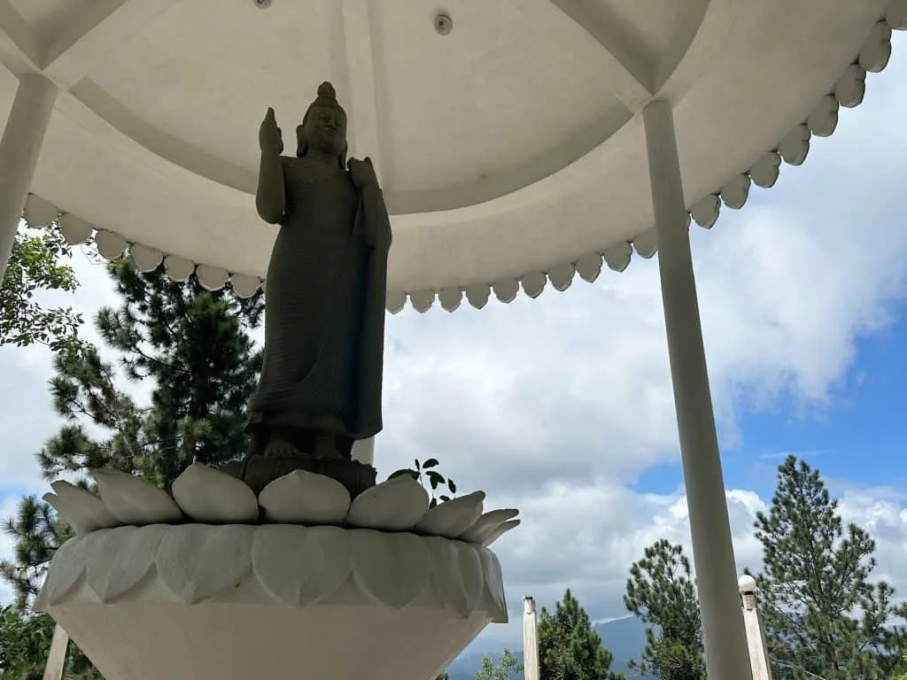 A Buddha statue stood in a pavilion beside the Ambuluwawa Tower