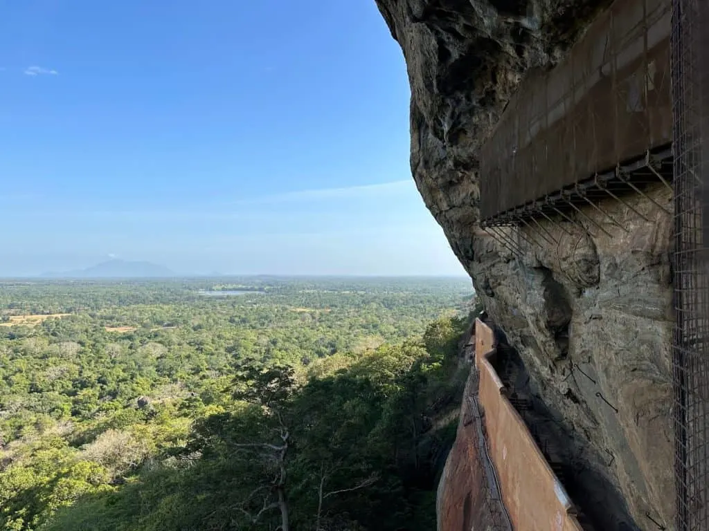 Covered frescos on side of Sigiriya with view of the jungle below