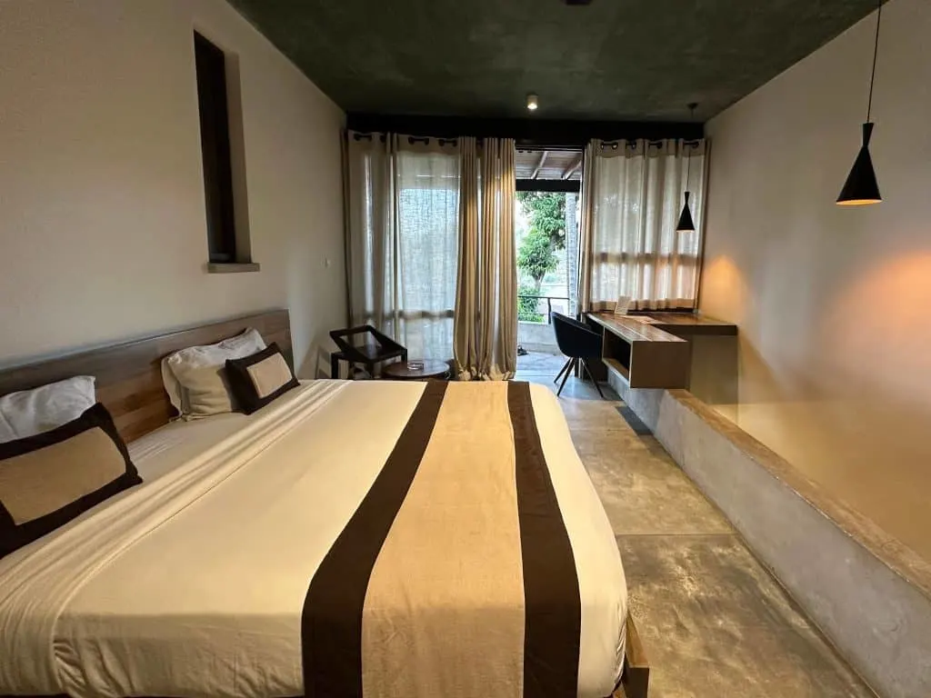 Hotel room with double bed at SWP Eco Lodge in Kandy, view towards balcony doors