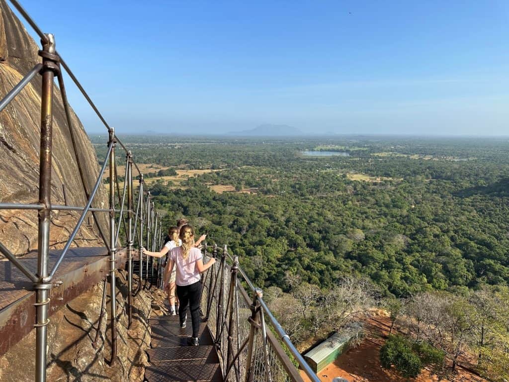 Family walking down the metal steps at Sigiriya with views of the jungle below