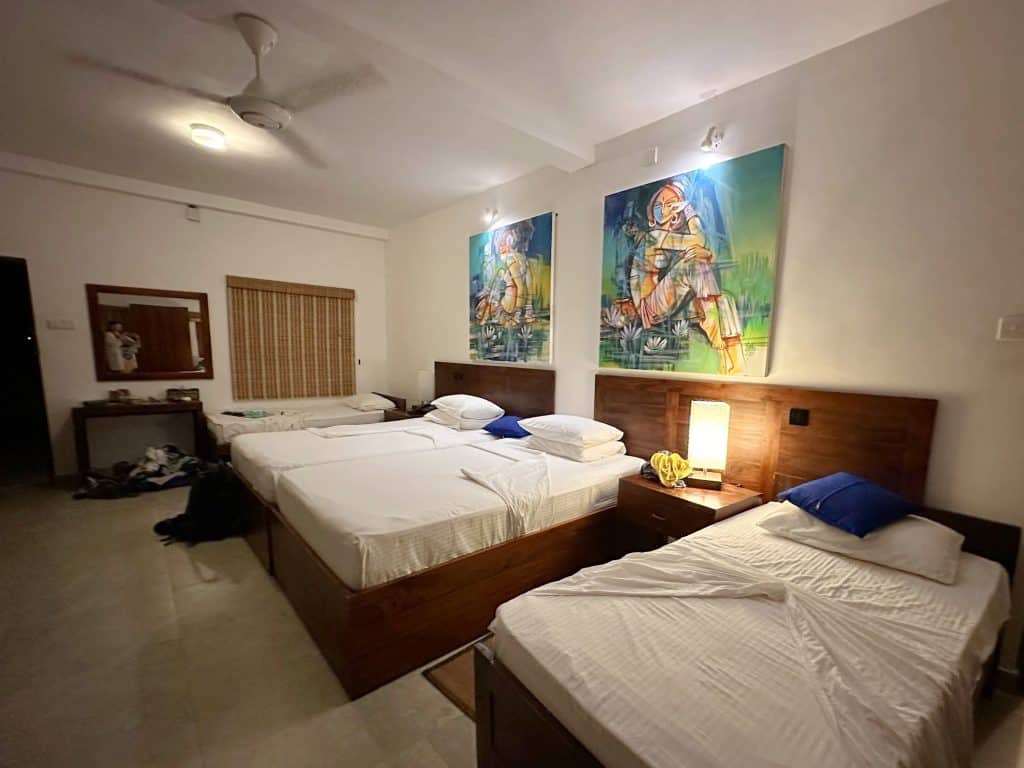 Double bed flanked by two single beds in the family room at Amaara Forest hotel