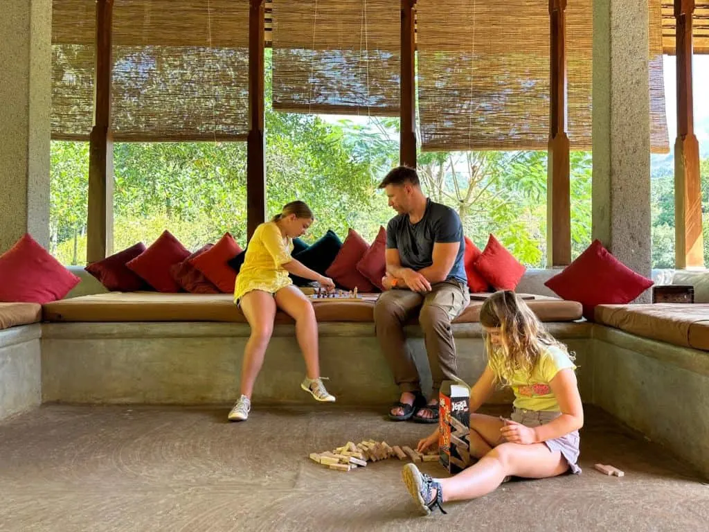 Mr Tin Box and daughters play board games in the communal pavilion at Koslanda