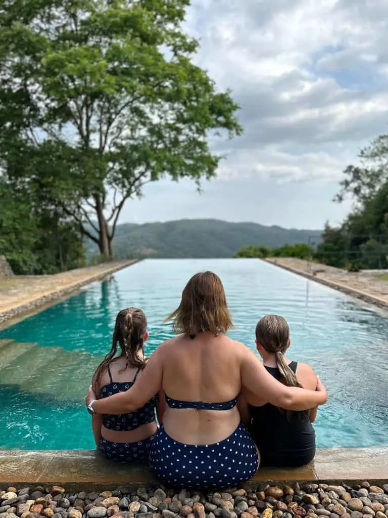 Claire and daughters sat on the edge of the infinity pool at Koslanda