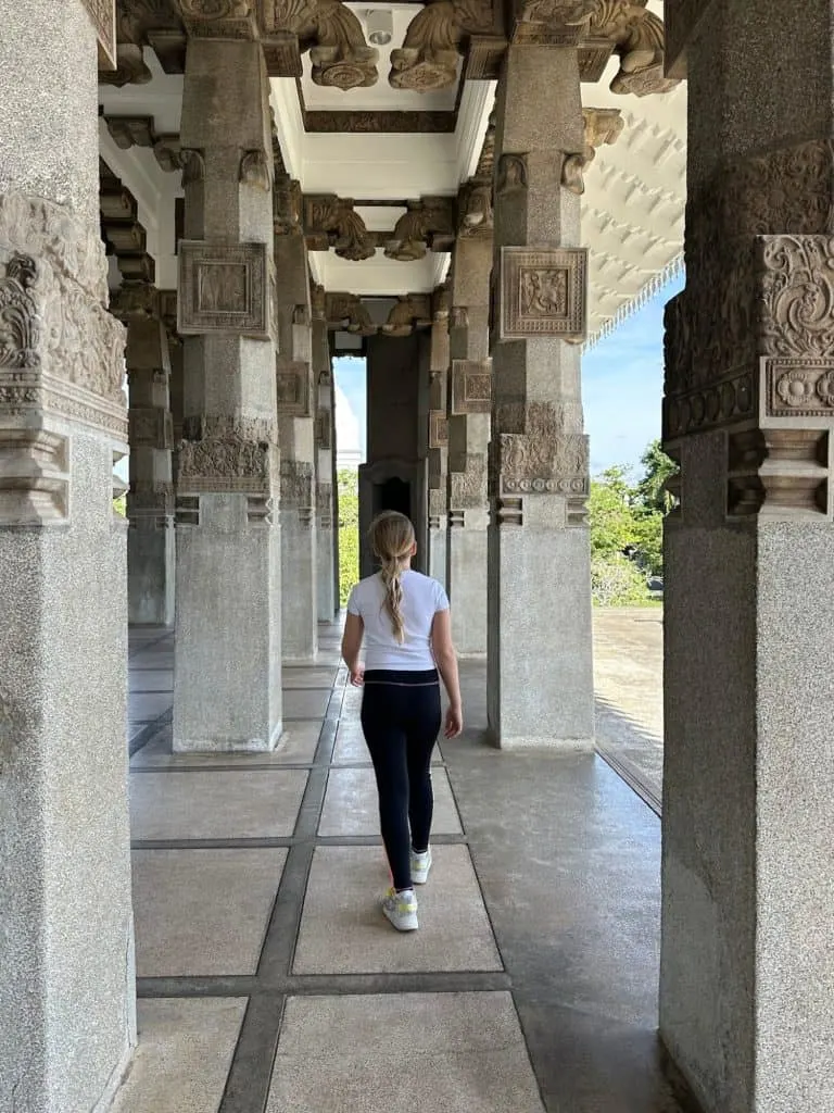 Ten year old walking between the stone columns of the Pavilion in Independence Square in Colombo