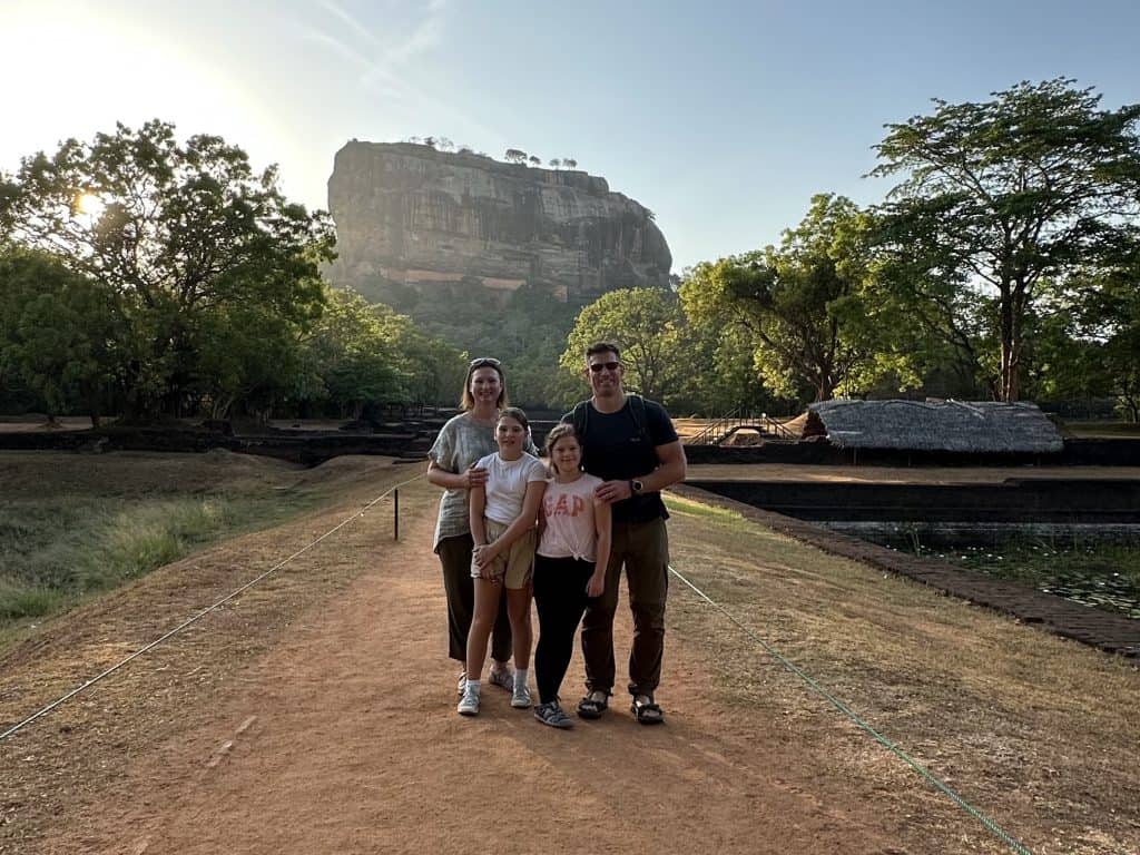 Family pose with Sigiriya rock in background at sunrise