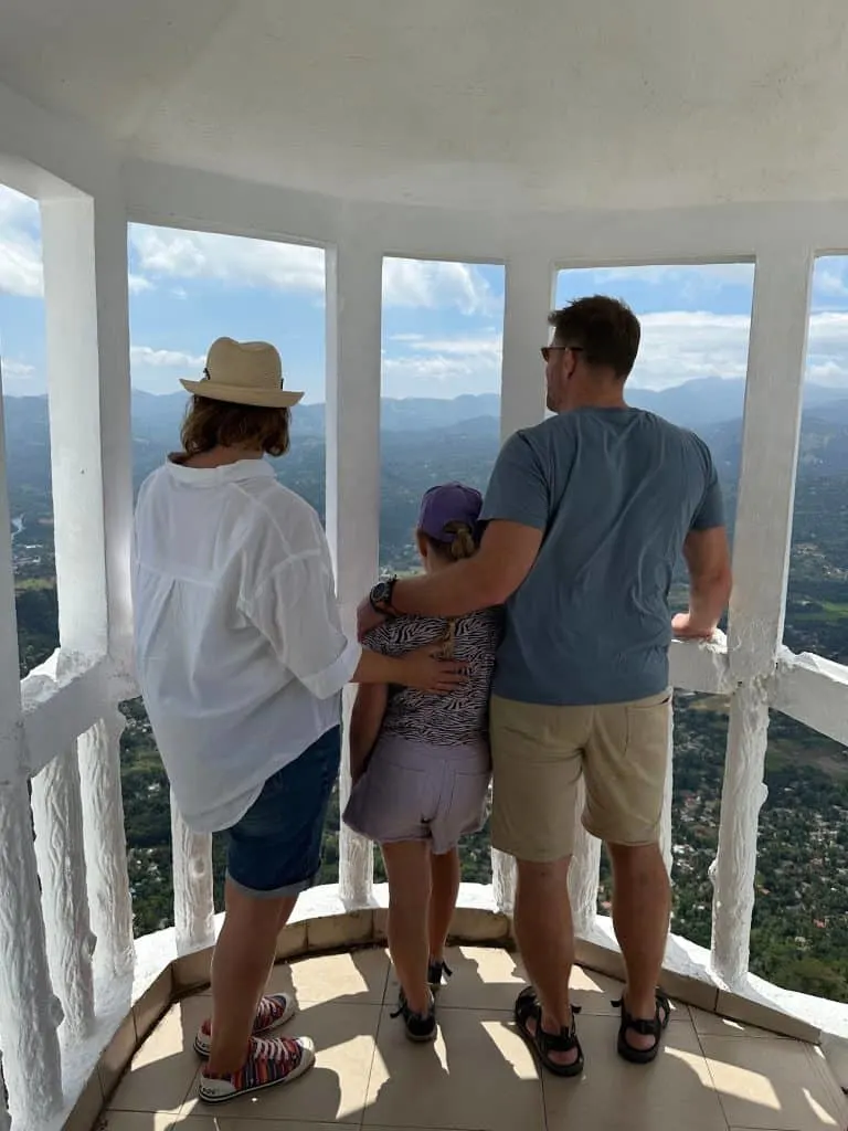 Tin Box family looking out of a balcony up Ambuluwawa Tower with views of the hills around them