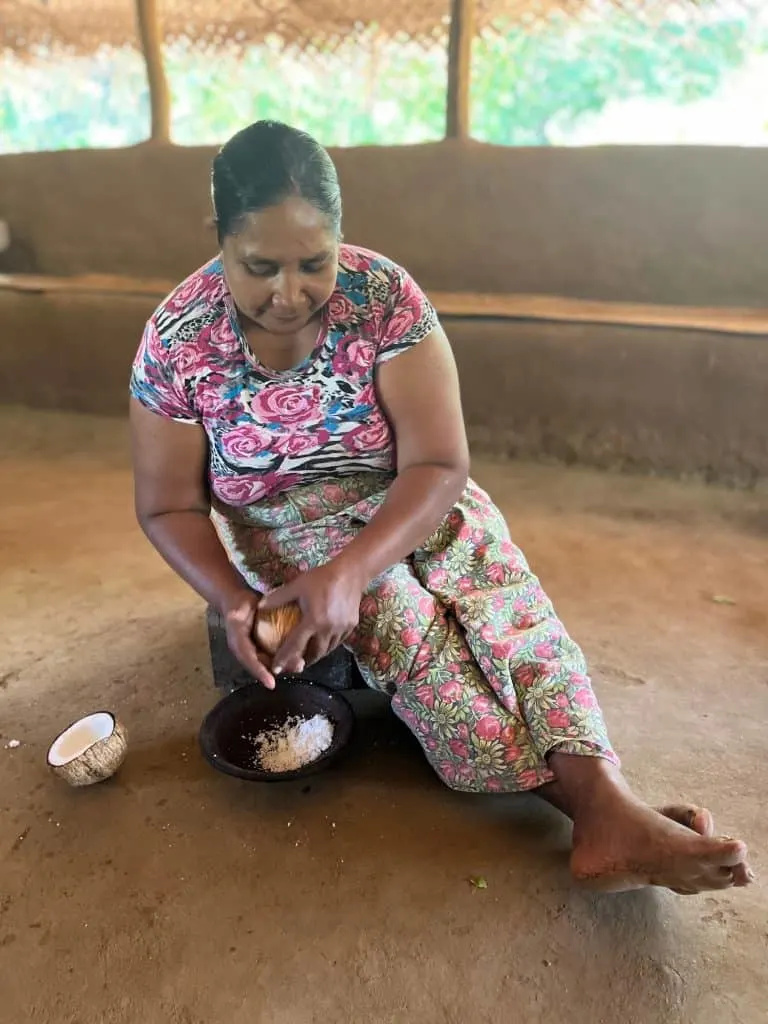 Lady in Hiriwidunna village shaving the inside of a coconut