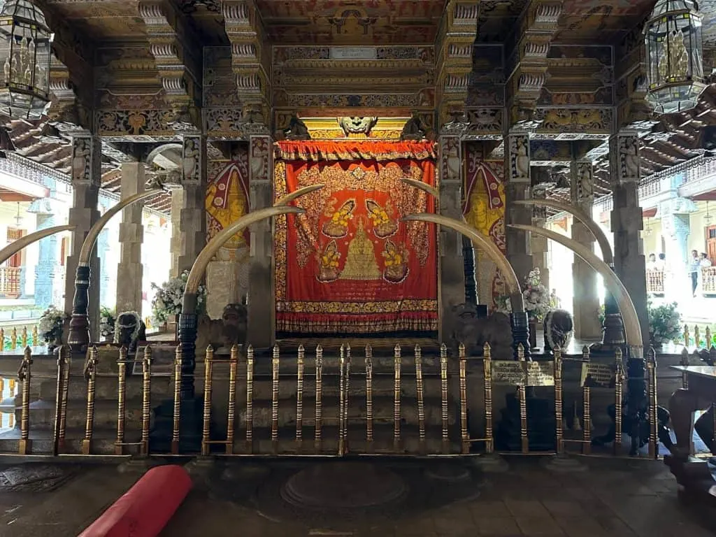 Elephant tusks and a elaborately decorated curtain cover the front of the Buddha's tooth relic shrine inside Sri Dalada Maligawa temple