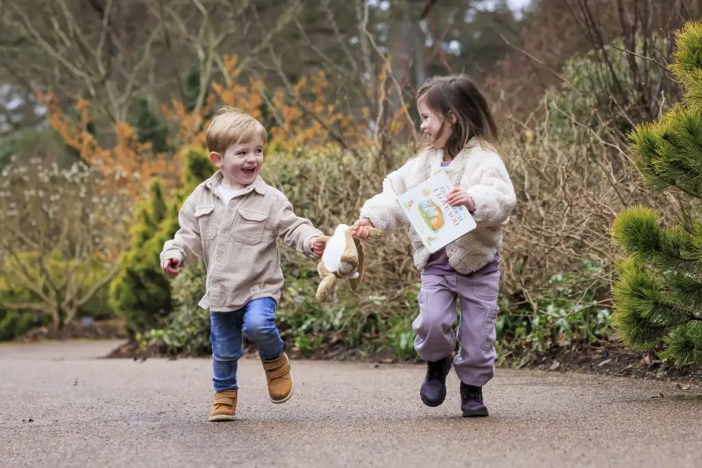 Children running through an RHS garden with a trail sheet