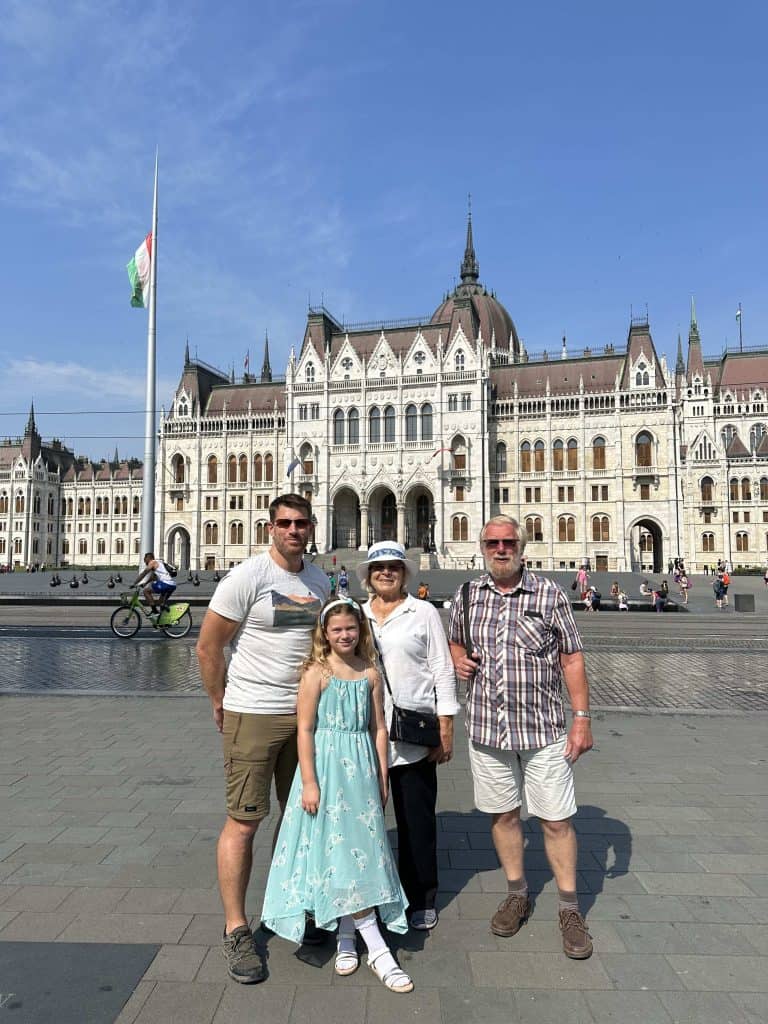 Mr Tin Box, his parents and our eight-year-old in front of the Hungarian Parliament budding which is modelled on the UK Parliament