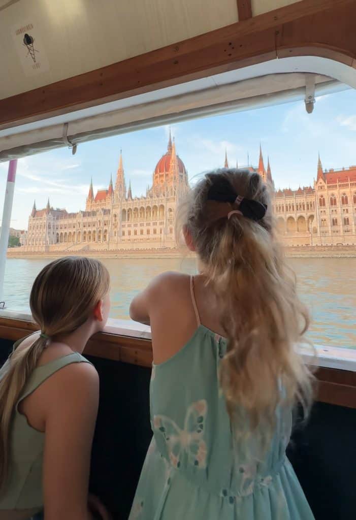 Our girls looking out of a boat window at the Hungarian Parliament. You can see the Danube River in-between