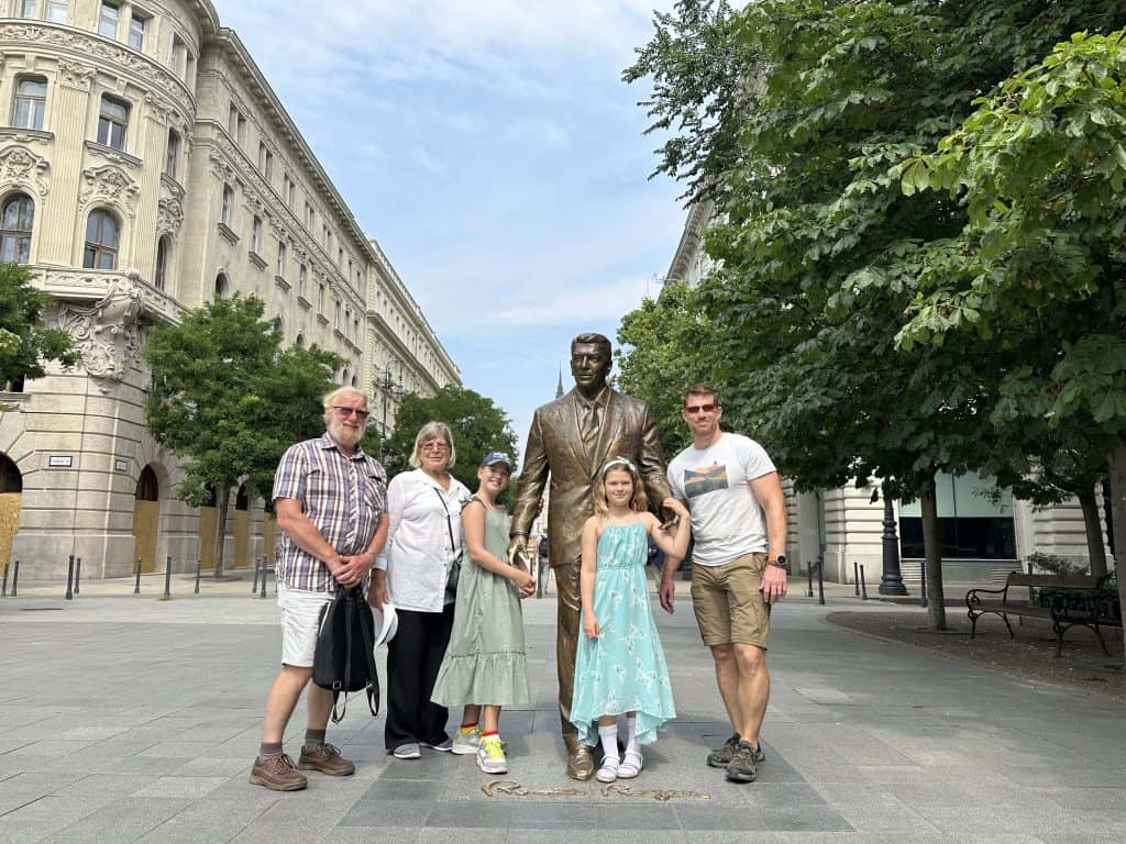 Mr Tin Box, his parents and out girls stood around a bronze statue of US President Ronald Reagan