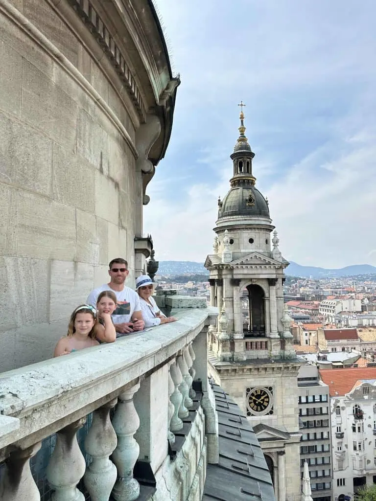 Mr Tin Box, his mum and out girls stood on the panoramic viewing platform at the top of St Stephen's Basilica. There's a view of the city behind them