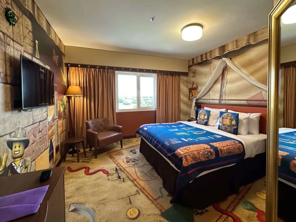 King-sized bed in a Adventure fully themed room at the LEGOLAND Dubai Hotel. The walls and carpet are decorated in a Egyptian adventure style