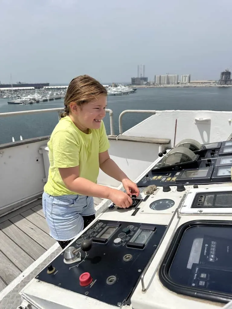 Our eight-year-old having fun using the small steering control on the bridge wing