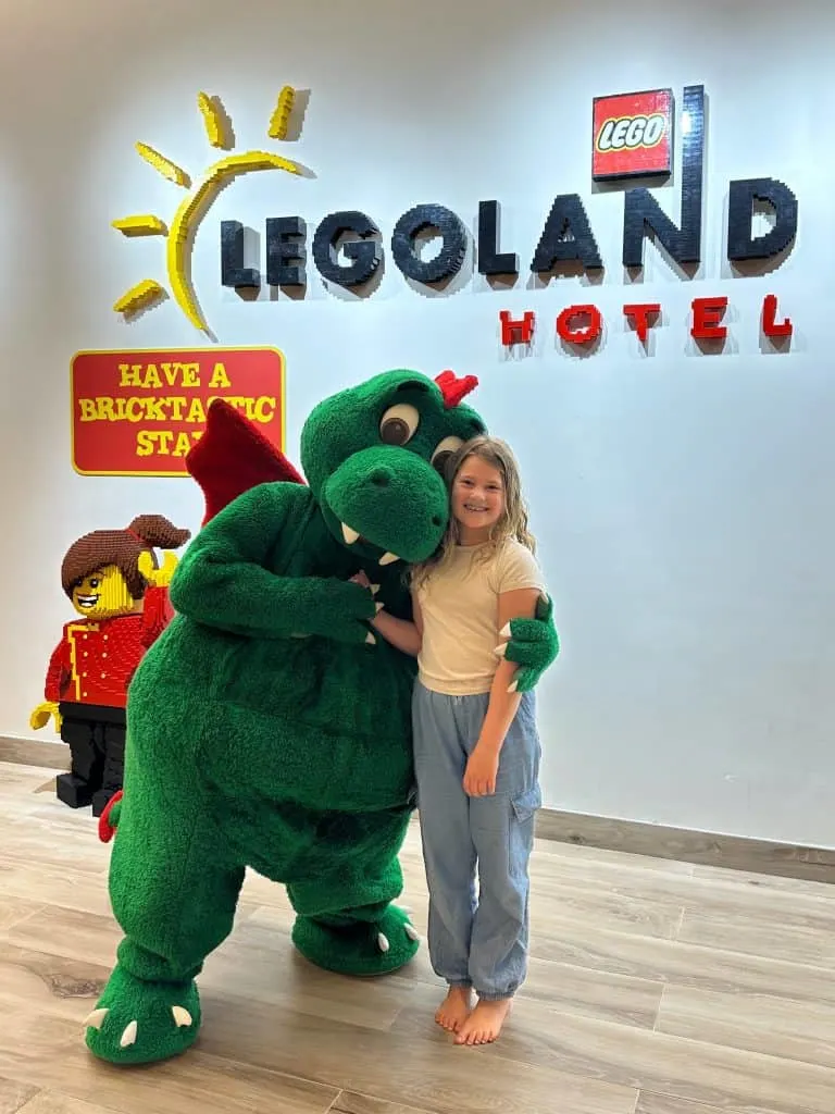 Our eight-year-old meeting the LEGOLAND dragon mascot in the lobby of LEGOLAND Dubai's hotel