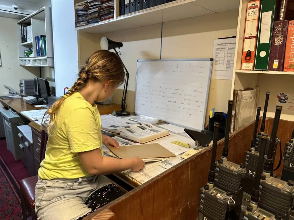 Our eight-year-old say looking at paper and books in the ship's chartroom during our tour